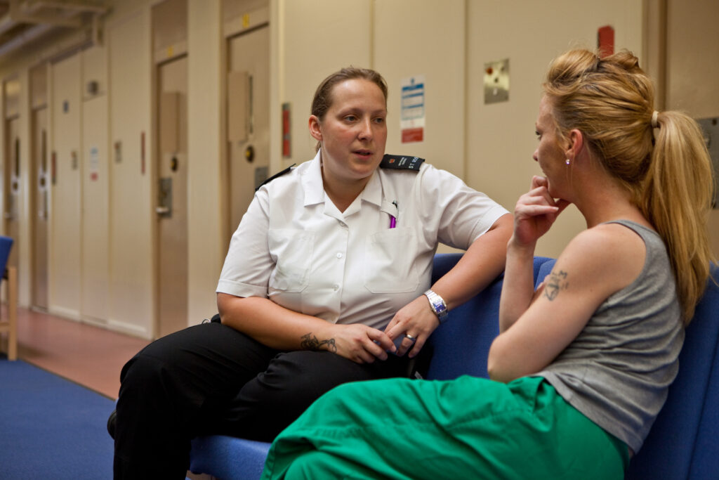 Women in prison talking to a prison guard